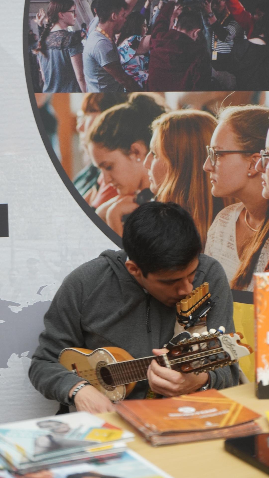 Missionar spielt Panflöte und Ukulele an seinem Stand auf der JUMIKO 2023