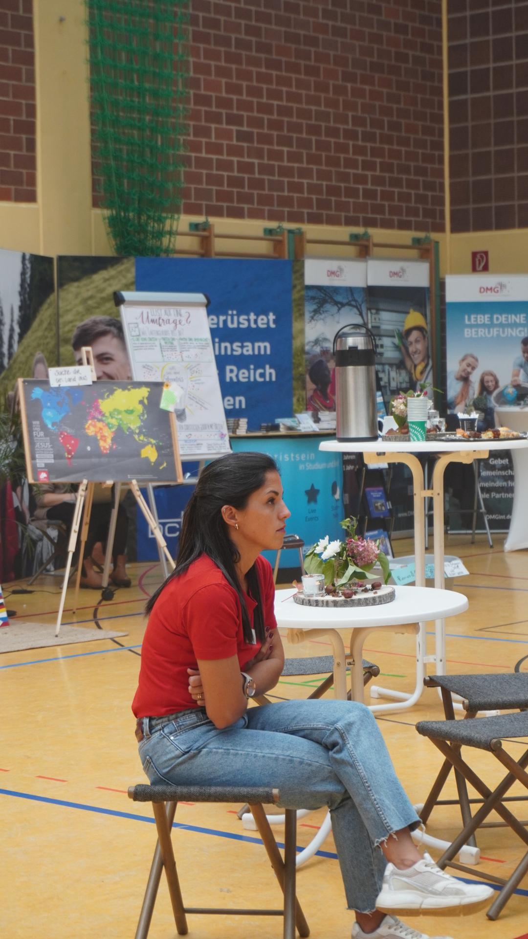 Missionsstände der JUMIKO 2023 mit Missionarin im Vordergrund