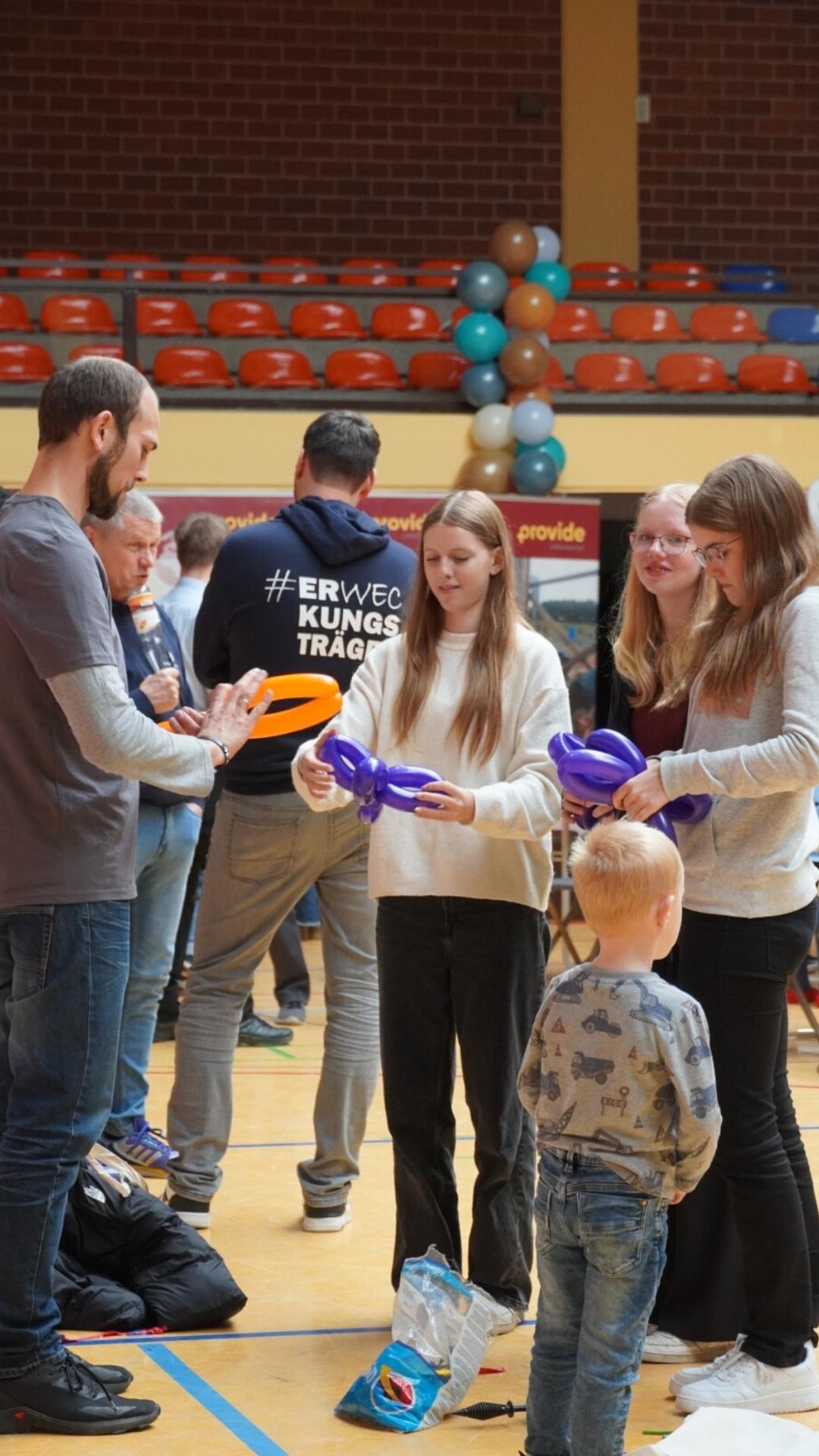 Missionar faltet Ballons für Kinder und unterhält Besucher auf der JUMIKO 2024