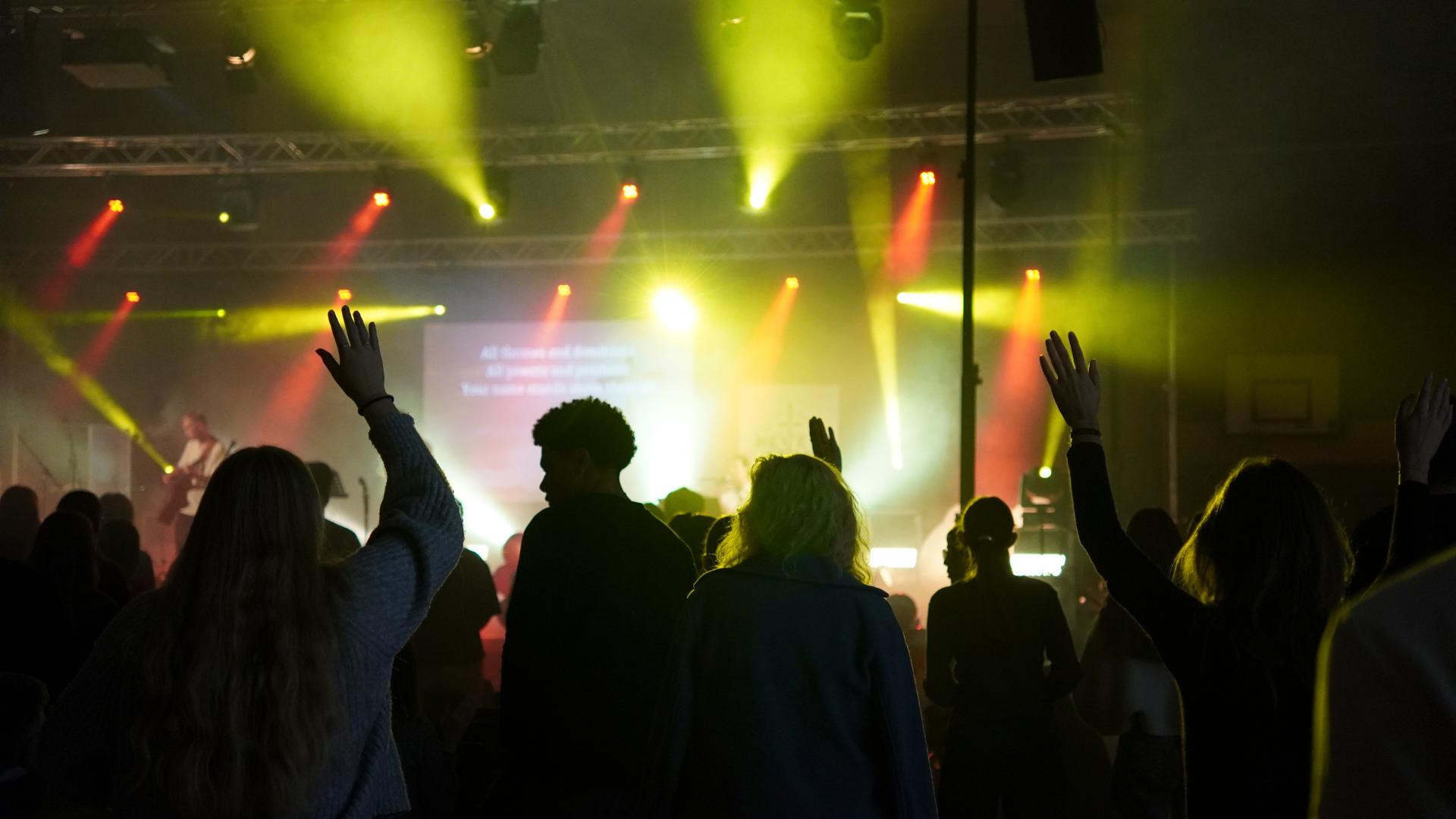 Lobpreisabend JUMIKO 2025 – Besucher mit erhobenen Händen, dahinter die Band und Lichtshow