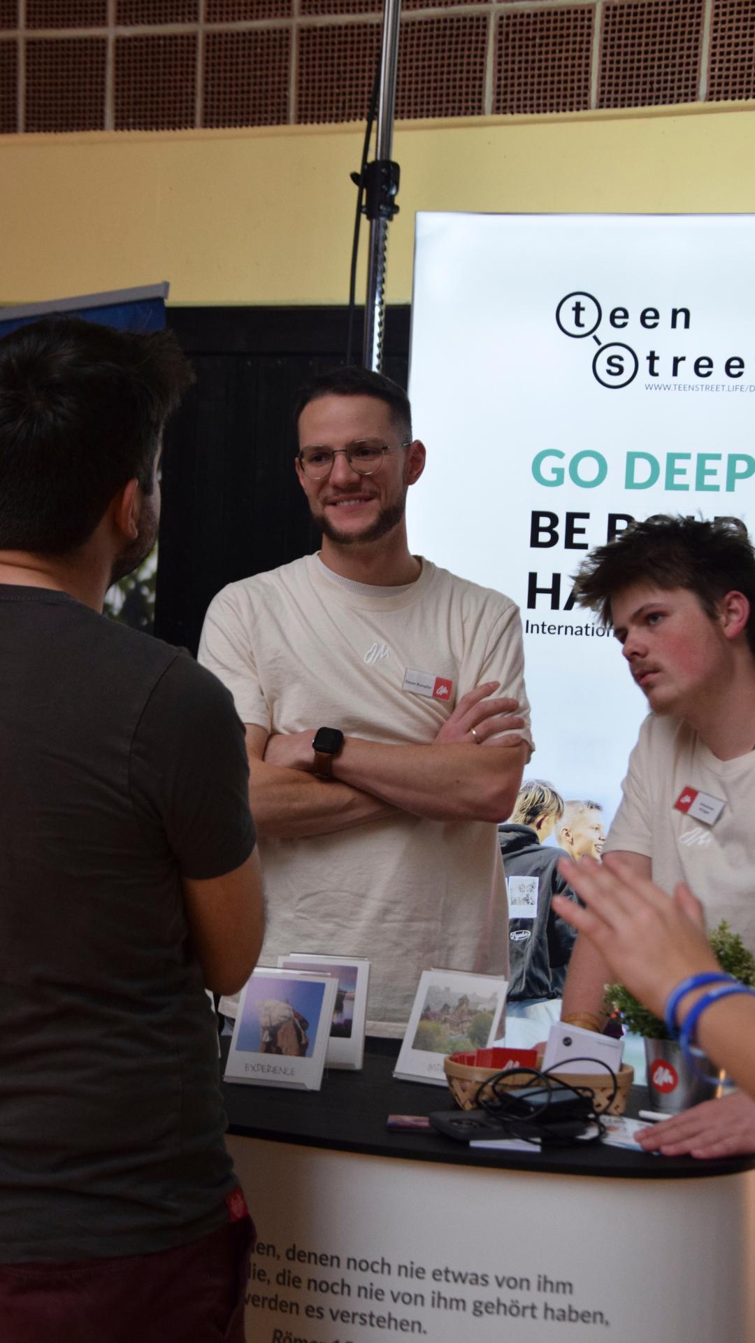 Besucher im Gespräch mit Missionaren am Informationsstand der JUMIKO Franken 2025